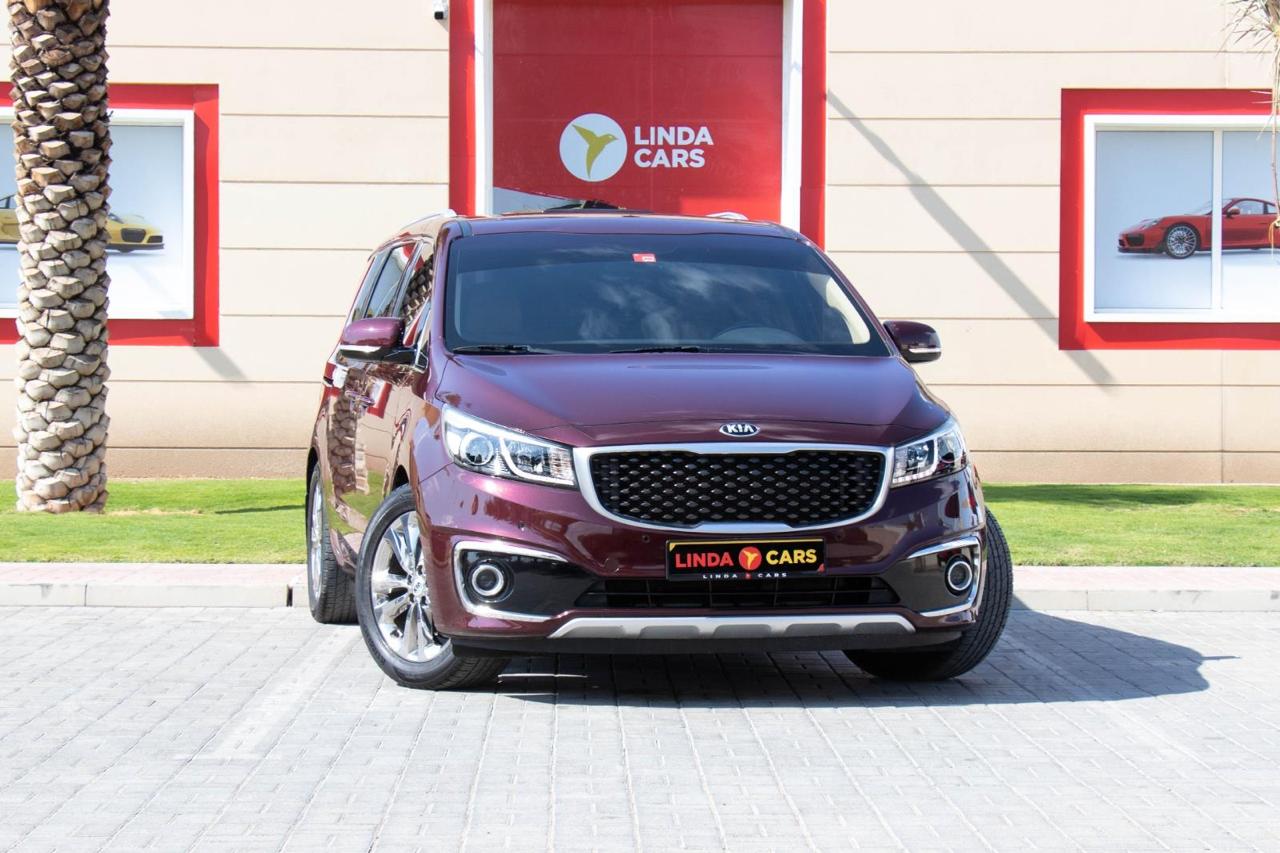 Maroon Kia Grand Carnival minivan