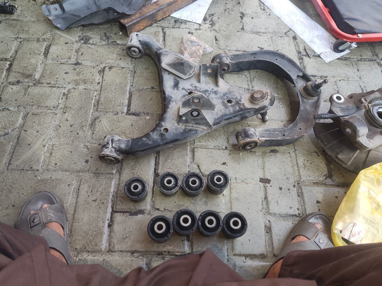 Control arm and suspension bushings laid out for replacement
