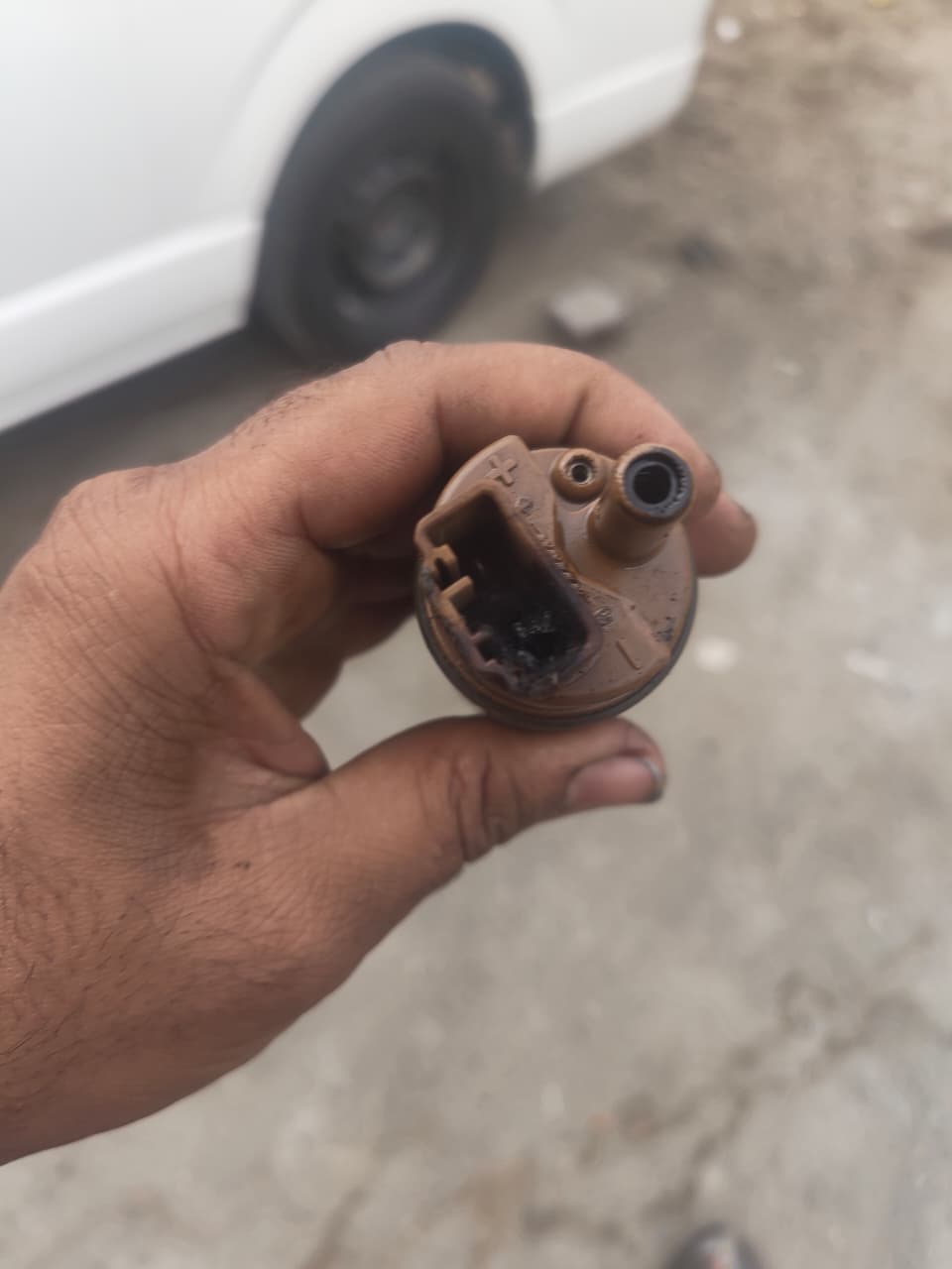 Technician holding a removed fuel pump component
